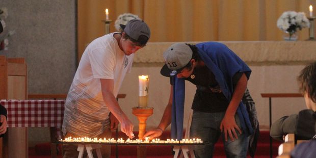 Teenagers light candles during a vigil for Hoani Korewha and Pacer Willacy-Scott. Photo / Andrew Bonallack