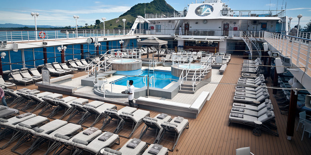 The sun-drenched sundeck featuring pool flanked by spa pools on Azamara Quest. Photo / Andrew Warner