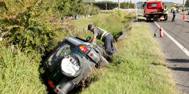 A Hawke's Bay Towing worker endeavours to remove the Toyota Rav 4 from a ditch on Pakowhai Rd.