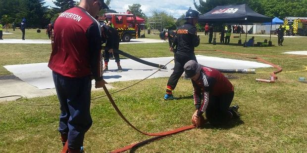 Prize-winning Carterton firefighters Mike Hicks and Steve Fennell asemble the hose at the Waterway Competition at Turangi. PHOTO/FACEBOOK