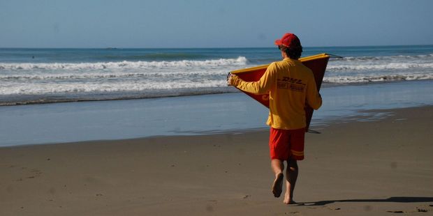 A lifeguard sets up the flags ahead of another day at the beach.
