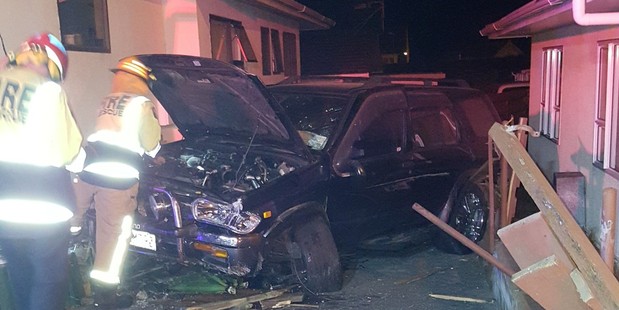 A vehicle came to a stop in a driveway between two homes facing the road.