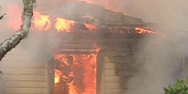Massive flames can be seen engulfing the property. Photo / Devon Venter