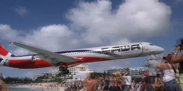 Mind your heads - Pawa Dominicana flight flies in low as it prepares to land at one of the "scariest" runways in the world. Photo / YouTube