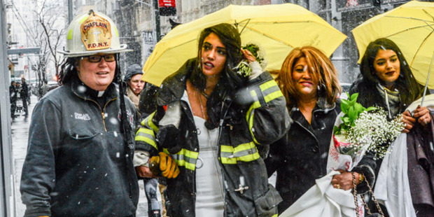 Nesh Pillay is assisted by FDNY Chaplain Rev. Ann Kansfield after a crane collapsed near the beauty salon where she was having her hair done. Photo / Getty Images