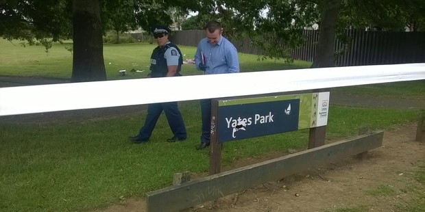 Police inspect a damaged sign at Yates Park after three men were shot. Photo / Simon Collins