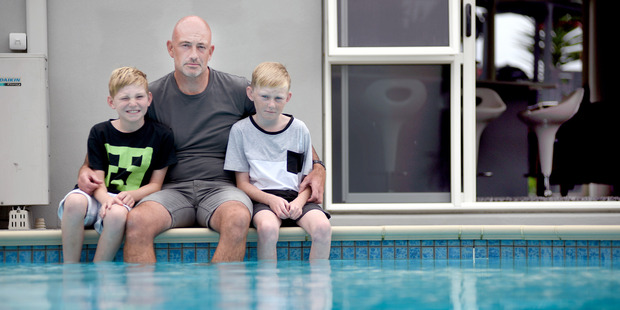 Rob Clark, pictured with sons Elliot, 9, and Cameron, 11, is upset new pool fencing regulations could set him back thousands of dollars. Photo / George Novak