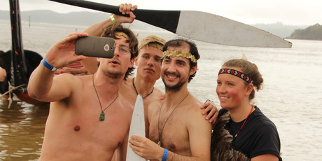 Dutch paddlers (from left) Thomas Driessen, Diederik Thompson, Alex Miesen and Mirte Hazes send a message to friends in Holland from Tii Beach. Photo / Peter de Graaf