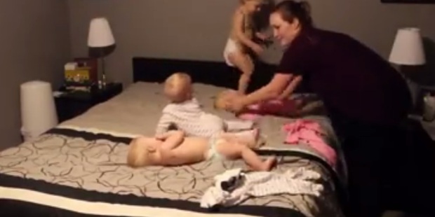 She manages to keep each child safe from falling off while individually dressing them. Photo / Youtube