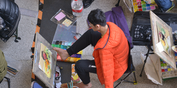 A student with no arms used his feet to paint as well as sketch. Photo / Getty
