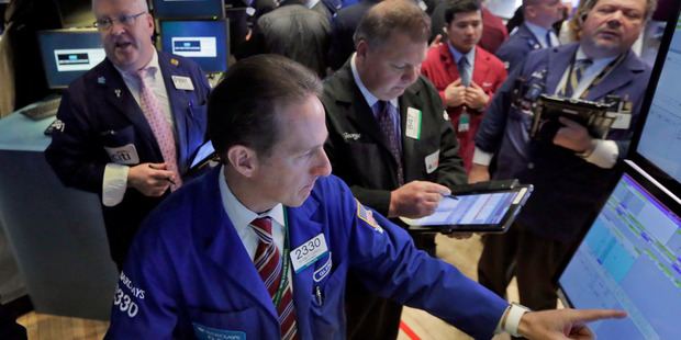 Specialist Glenn Carell, foreground, works with traders at his post on the floor of the New York Stock Exchange. File photo / AP