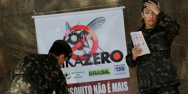 Army soldiers set a banner that reads in Portuguese "A mosquito is not stronger than a whole country" at the Central station, in Rio. Photo / AP