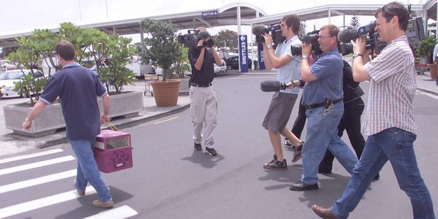 Colin's is greeted by the New Zealand media on arrival back at Auckland International Airport. Photo / NZ Herald
