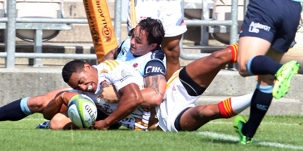Chiefs winger Glen Fisiiahi scores in the tackle of Waratahs player Zac Guildford during the pre-season Super Rugby match in Rotorua last Friday.