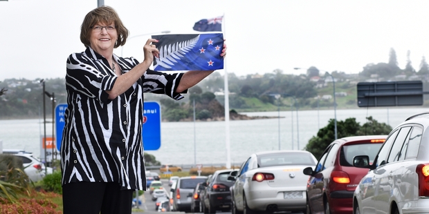 Councillor Gail McIntosh, who supports change, holds the alternative flag. Photo / George Novak