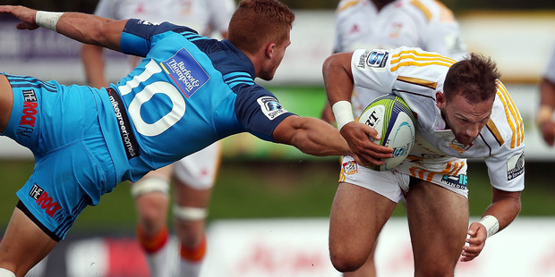 Aaron Cruden attempts to evade the attention of Ihaia West at Pukekohe. Photo / Getty