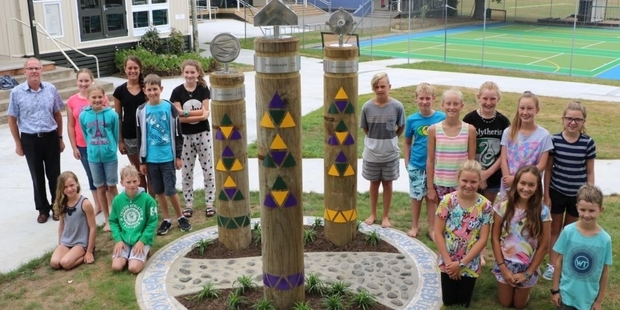 The centennial community art piece designed by principal Phil Missen (pictured back left).