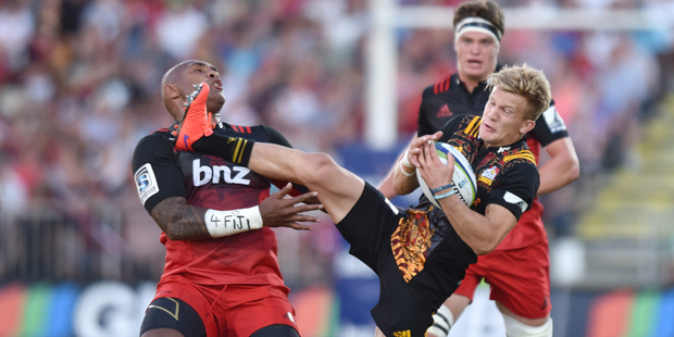 Damian McKenzie of the Chiefs charges over Nemani Nadolo of the Crusaders during the round one Super Rugby match between the Crusaders and the Chiefs. Photo / Getty Images