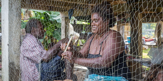 Woman repairing fishing nets. Photo / Getty Images