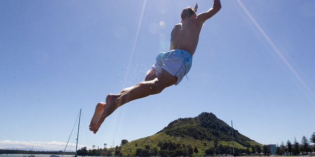 William Clague takes a big leap into the cool waters of Pilot Bay in Tauranga Harbour today. Photo / Alan Gibson