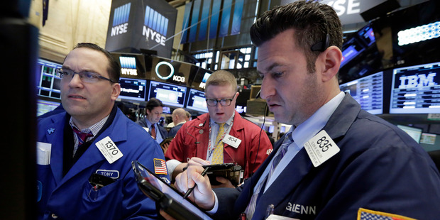 Specialist Anthony Matesic, left, works at his post on the floor of the New York Stock Exchange with traders Ryan Falvey, center, and Glenn Kessler. Photo / AP