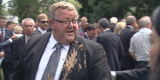 Gerry Brownlee reacts after having a brown goo tipped on him whilst attending the memorial service for the 2011 earthquake in Christchurch. Photo / Joe Morgan