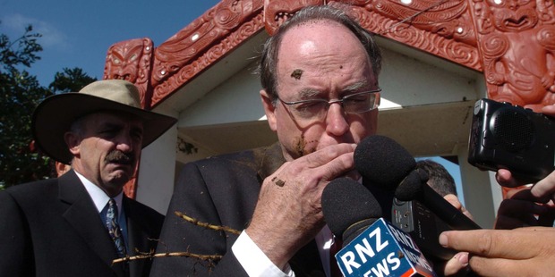 Don Brash is hit in the face by mud thrown from a protester at the entrance to Te Tii Waitangi Marae. Photo / Getty Images