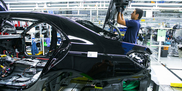 An employee secures electric cables inside the trunk of a Mercedes-Benz S-Class automobile on the assembly line at Daimler's Mercedes-Benz factory in Sindelfingen, Germany. Photo / Bloomberg