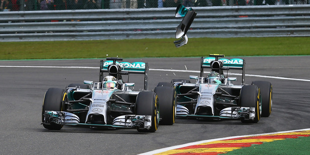 Debris flies in the air as Nico Rosberg makes contact with Lewis Hamilton. Photo / Getty Images
