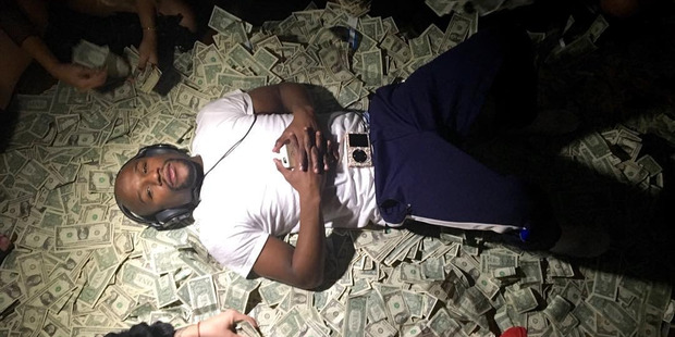Photo posted to Instagram by Floyd Mayweather showing the boxer lying on a pile of money. Photo / Instagram