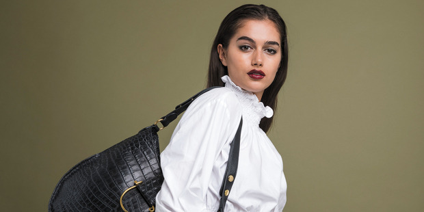Maia carries a Deadly Ponies 'Mr Piper Croc' bag, $730; and wears an H&M top, $40. Karen Walker nine-carat gold tiger's eye cocktail ring, $839.