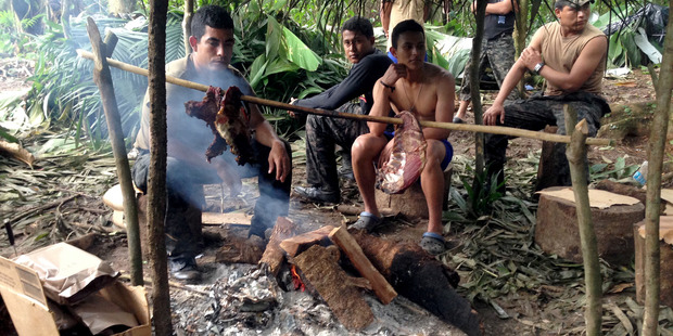 Honduran Special Forces soldiers accompanying the expedition roast a deer over their campfire. Photo: Douglas Preston / Washington Post