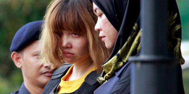 Vietnamese suspect Doan Thi Huong, centre, in the ongoing assassination investigation, is escorted by police officers out from Sepang court. Photo / AP