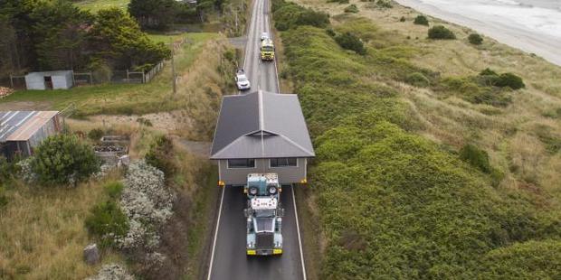 A house built at the Otago Polytechnic Architecture, Building and Engineering School in Dunedin, nears its final destination at Big Stone Rd, near Brighton. Photo / Hayden Parsons