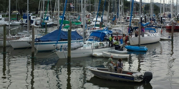 Boaties attempt to stop a yacht sinking at its mooring at Whangarei's Town Basin Marina today.