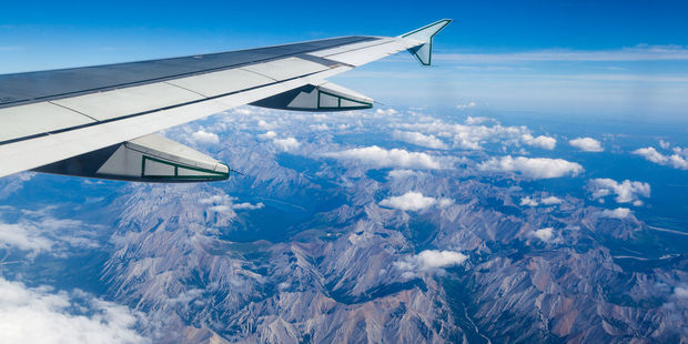 A plane flies over the Rocky Mountains. Photo / 123RF