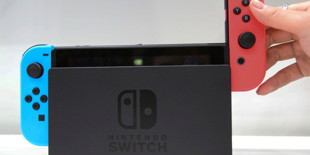 Sliding the controllers off the docked Switch console.
