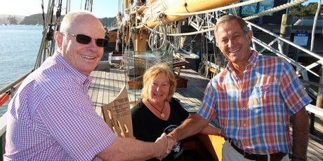 Regional council chairman Bill Shepherd, left, presents the Sailor of the Year trophy to R Tucker Thompson Sail Training Trust trustees Mike Simm and Jane Hindle at Opua. PHOTO / SUPPLIED