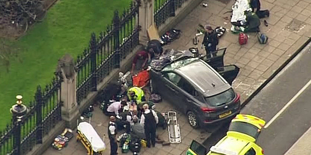 In this image taken from video police officers gather around a car adjacent to Houses of Parliament in London. Photo / AP