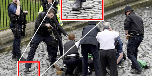 Two knives are visible on the ground outside the Palace of Westminster as paramedics work on the alleged attacker. Photo / AP