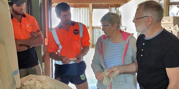 Landcorp employees Peter O'Malley (left) and Mace Lee, from Waipori Station, talk wool with Nanny and Ove Glerup Kristensen. Photo/Richard Brewer