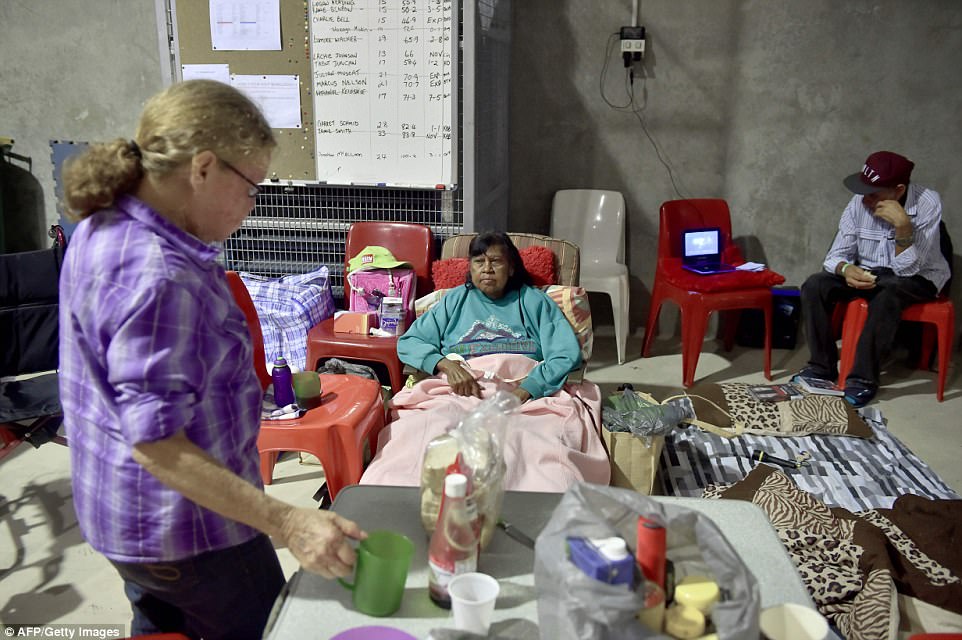 A woman could be seen lying on a makeshift bed as others sat on plastic chairs in an evacuation centre today. Photo/Getty Images