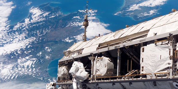 Astronuats Robert L Curbeam (left) and Christer Fuglesang work on the International Space Station while in orbit over New Zealand, offering the pair a jaw-dropping view of Wellington.
