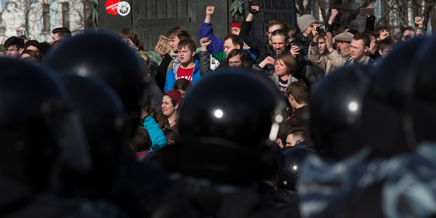 People shout anti-government slogans in front of police during a protest downtown Moscow. Photo / AP