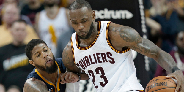 Indiana Pacers' Paul George, left, reaches for the ball as Cleveland Cavaliers' LeBron James drives to the basket in overtime. Photo / AP