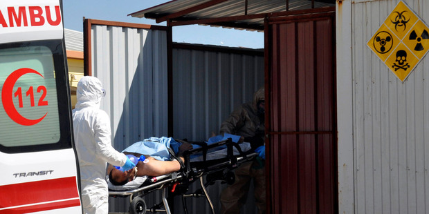 Turkish experts evacuate a victim of a suspected chemical weapons attacks in the Syrian city of Idlib. Photo / AP