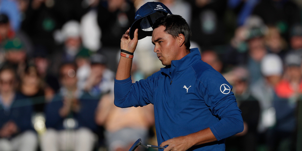 Rickie Fowler tips his hat on the 18th green during the second round of the Masters golf tournament. Photo / AP