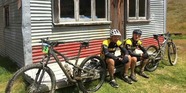 Greg Bowker and Michael Brown enjoy a stop during the Queens Stage day five of the Pioneer Mountain bike ride through the South Alps of New Zealand. Photo / Greg Bowker