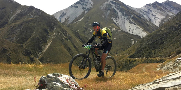 Michael Brown climbs one of the hills during Queens Stage day five of the Pioneer Mountain bike ride through the Southern Alps of New Zealand. Photo / Greg Bowker