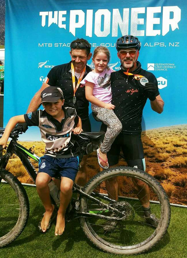 Michael Brown (right) with his children and team mate Greg Bowker (left) at the finish line of the Pioneer bike race. Photo / Supplied